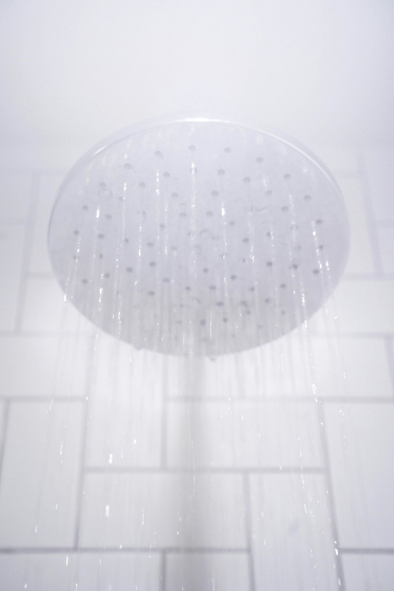 water from round gray stainless steel shower head